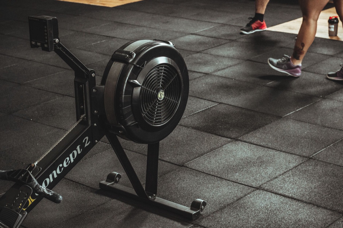 A person training on a rowing machine in a professional gym setting.