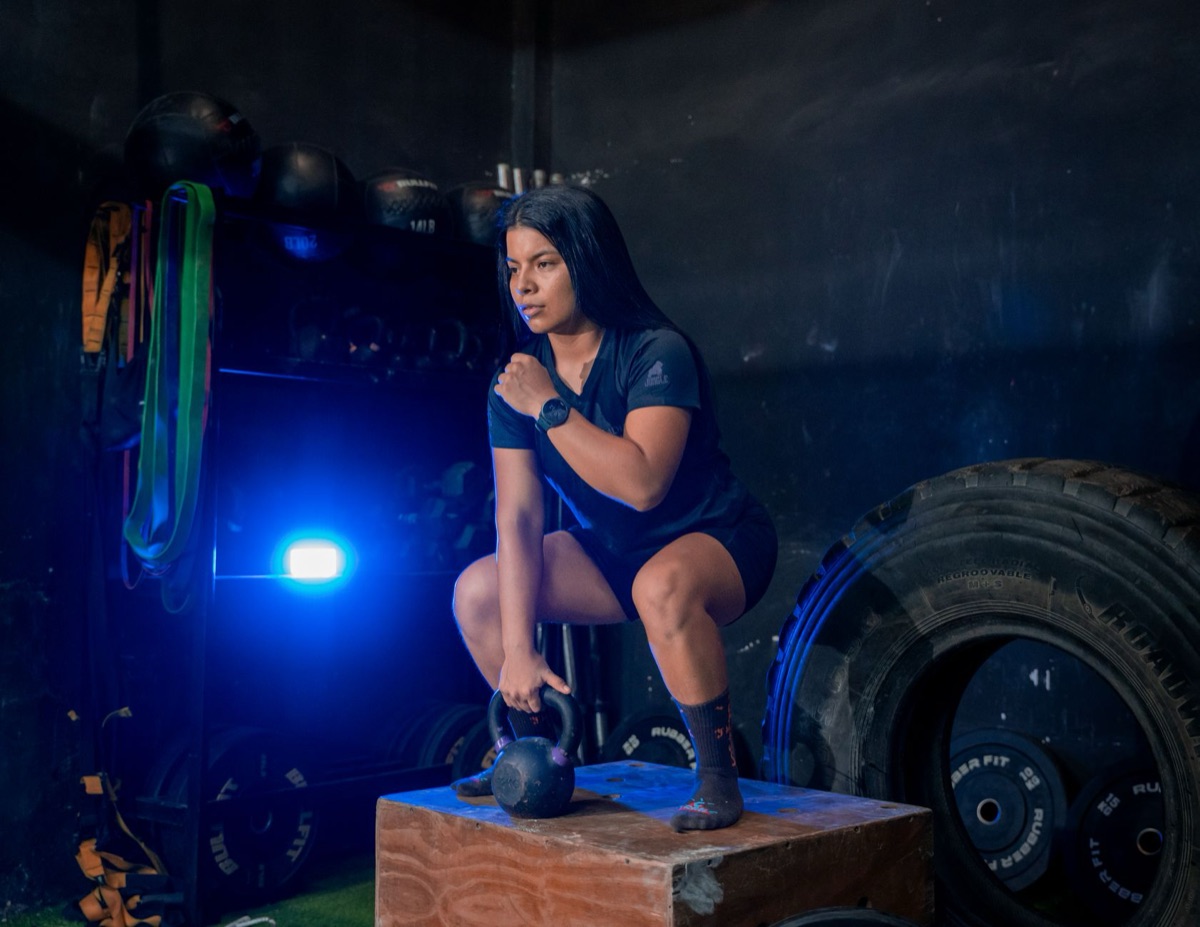 A person performing a goblet squat with a heavy kettlebell for strength training.