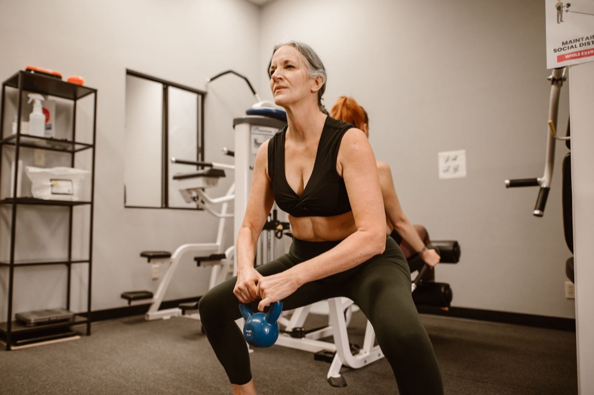 Une personne effectuant des fentes avec des kettlebells.