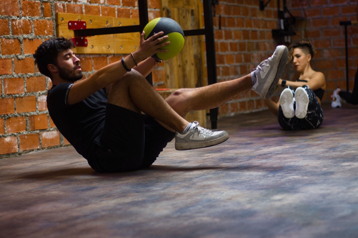 Een atleet die een medicine ball tegen de muur werpt